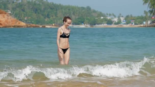 Senhora suave sorri e caminha para fora do mar tropical azul brilhante — Vídeo de Stock