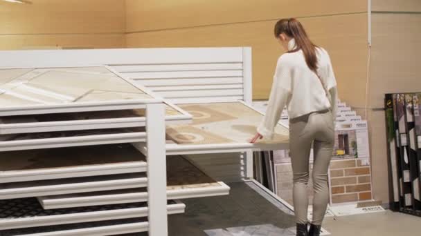 Giovane donna sceglie modello astratto sul piano di lavoro per tavolo — Video Stock