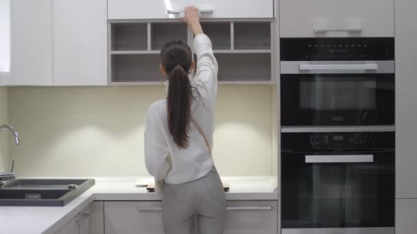 Młoda kobieta dotyka białych półek i rozgląda się dookoła — Wideo stockowe