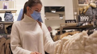 At kuyruklu profesyonel alışverişçi kışlık cekete bakar.