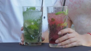Bayan eller restoranda kokteyl bardaklarını tutar ve kaldırır.