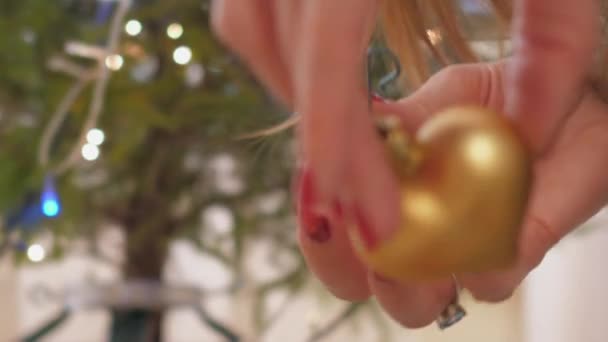 Brinquedo de Natal dourado em forma de coração em mãos de mulher — Vídeo de Stock