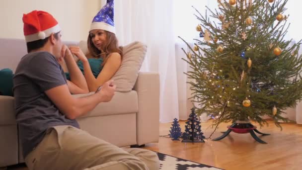 Happy married couple in Santa hats talks about Christmas — Stock Video