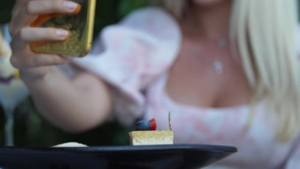 Ciasto kawałek przeciwko pani trzyma złoty smartfon w ręku — Wideo stockowe