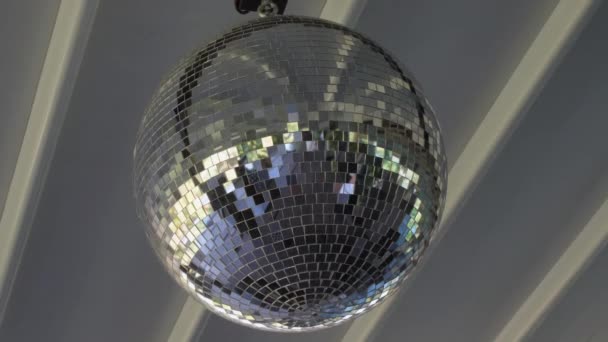 Ronde zilveren discobal hangt aan het witte plafond van restaurant — Stockvideo