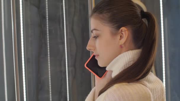 Brunette with long hair in ponytail walks along store — Stock Video