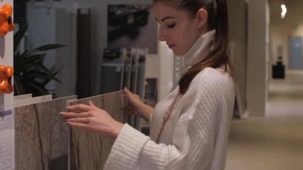 Jovem mulher se move diferentes modelos de telha cerâmica — Vídeo de Stock