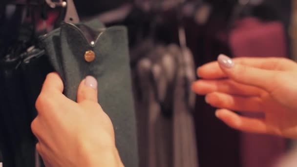 Jovem mulher mãos pendurar luvas de caxemira verde na loja — Vídeo de Stock