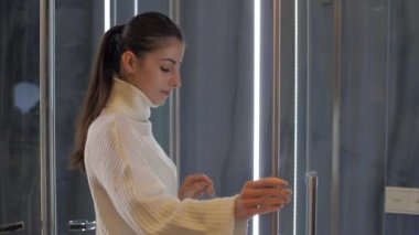 Beyaz kazaklı deneyimli tasarımcı duş kabini açıyor.