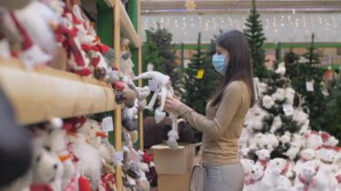 Bayan elinde kış oyuncaklarıyla mağazada dolanıyor.