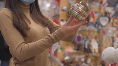 Uzun saçlı esmer, farklı renklerde mücevherler taşıyor.