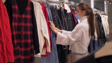 İnce alışverişkolik askılarda mavi kot pantolona dokunuyor