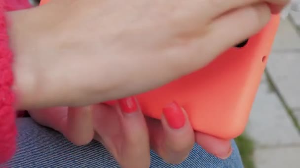Dame reinigt Smartphone in orangefarbenem Etui mit Feuchttuch — Stockvideo