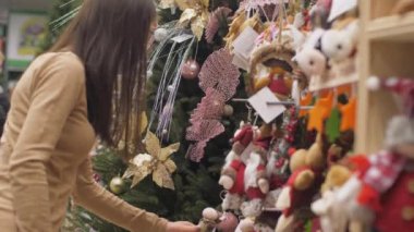 Alışverişçi renkli Noel ağacı süslemelerini seçiyor