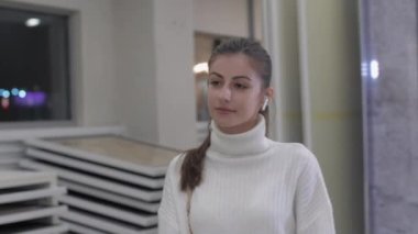 Genç kadın mağazadaki büyük aynada yansımaya bakıyor.