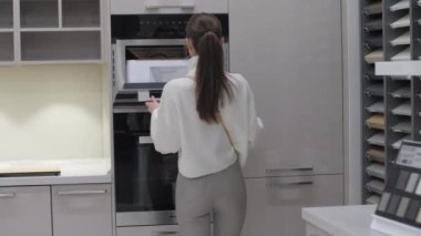 At kuyruklu kadın, Matt Fayans menzilinde siyah fırına bakıyor.