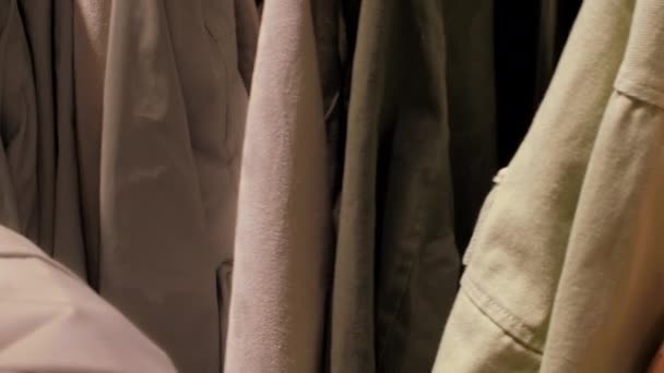 Doświadczony shopper ręce dotknąć kolorowe ciepłe kurtki — Wideo stockowe