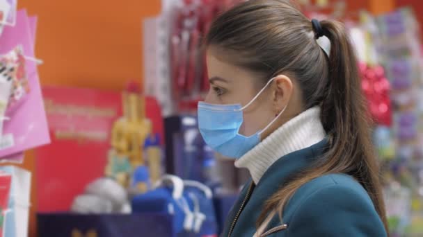 Jonge vrouw met blauw masker tussen gekleurde cadeauverpakkingen — Stockvideo