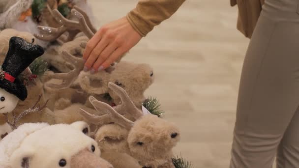 プロの買い物客は手で茶色の鹿のおもちゃを取る — ストック動画