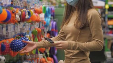 Profesyonel alışverişçi raftaki mavi hayvan topuna bakar.