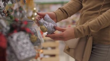 Profesyonel tasarımcının elinde gri Noel ağacı süsü var