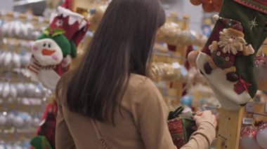 Profesyonel alışverişçi Noel çorabını elinde tutuyor