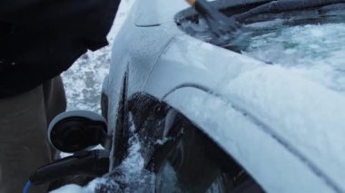 Elektrikli araç camından buz parçaları çıkartılıyor