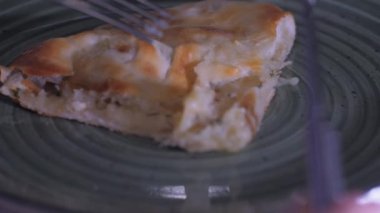 Gümüş çatal tutan kişi lezzetli pizzadan bir parça alır.