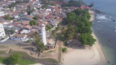 Galle Kalesi 'ndeki küçük bir kasabanın yakınındaki deniz feneri ve palmiye ağaçları.