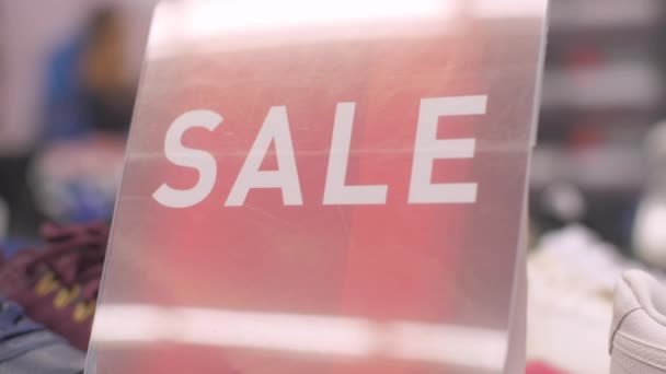 Försäljning tecken på röd färg med bokstäver bland vinterskor — Stockvideo
