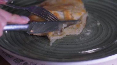 İnsan gümüş çatal ve bıçakla lezzetli pizza dilimleri keser.