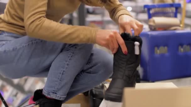 Profi-Shopaholic probiert neue schwarze Winterschuhe an — Stockvideo