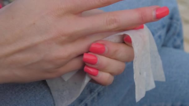 Mujer con uñas rosadas limpia las manos con toallita húmeda de cerca — Vídeos de Stock