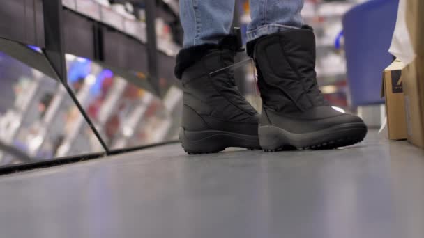 Shopaholic in neuen schwarzen Winterschuhen steht neben Spiegel — Stockvideo