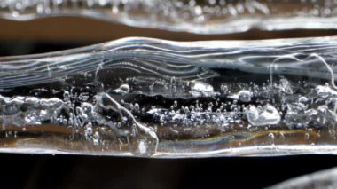 Farklı şekillerde kabarcıkları olan büyük şeffaf buz sarkıtı