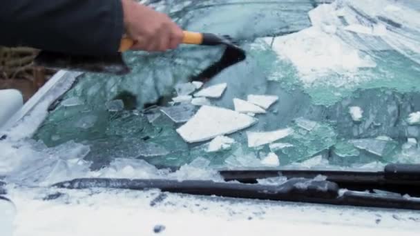 L'anziano tiene in mano raschiaghiaccio e pulisce il parabrezza — Video Stock