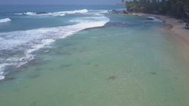 Sarı sahil şeridinde köpüklü okyanus dalgaları