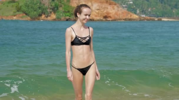 Sportowa kobieta cieszy się gorącą pogodą tropikalną przed falującym morzem — Wideo stockowe