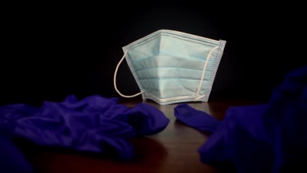 Wrinkly sterile gloves against disposable face mask — Stock Video