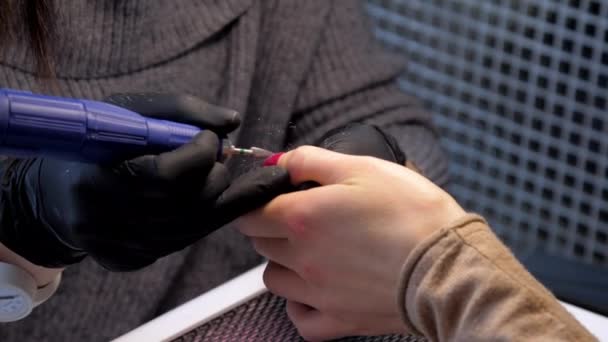Εξειδικευμένος αισθητικός σε μαύρα γάντια χειρίζεται το μανικιούρ γυναικών — Αρχείο Βίντεο