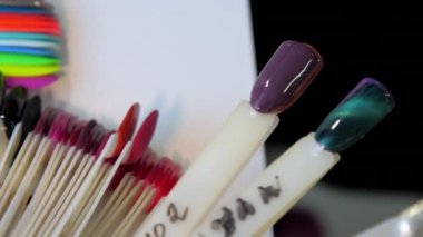 Tabloların olduğu farklı manikür örnekleri masanın üzerinde.