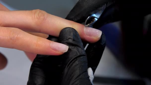 Geschoolde schoonheidsspecialiste verwijdert nagelriemen van vrouwelijke nagels — Stockvideo