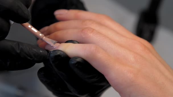 Manicurista experimentado aplica capa de gel en la uña — Vídeos de Stock