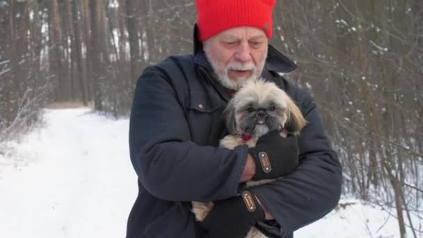 Sakallı yaşlı adam tüylü, titreyen köpeği kollarında tutuyor. — Stok video