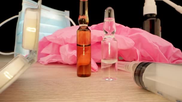 Frascos para injetáveis de vacina seringa e luvas estéreis cor-de-rosa jazem na mesa — Vídeo de Stock