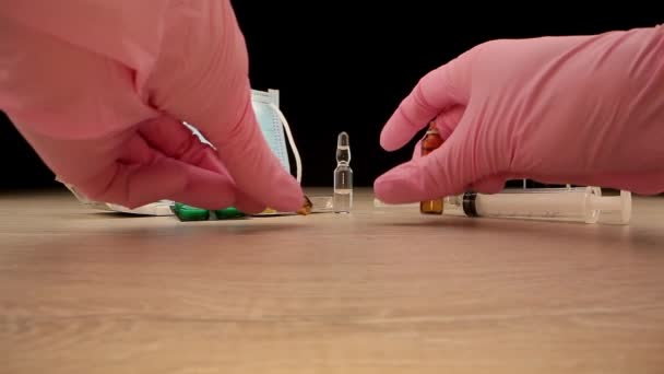 De arts in handschoenen opent de injectieflacon en krijgt het vaccin in de spuit — Stockvideo