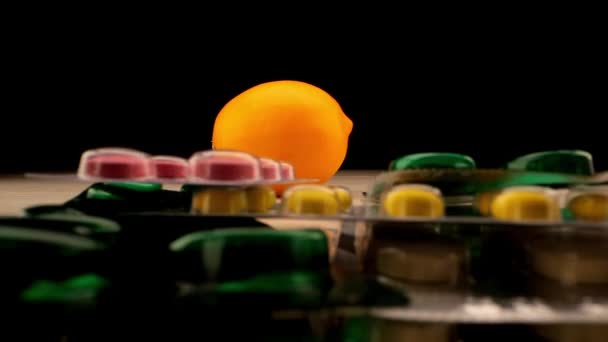 Mãos de pessoa colocar pílulas antibióticas na pilha contra laranja — Vídeo de Stock