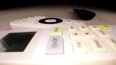 Siyah beyaz uzaktan kumandaları toplayan kişi