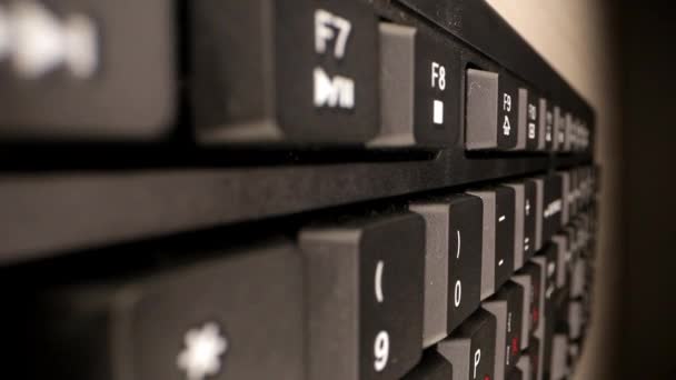 Чорна комп'ютерна клавіатура з білими знаками на коричневому столі — стокове відео