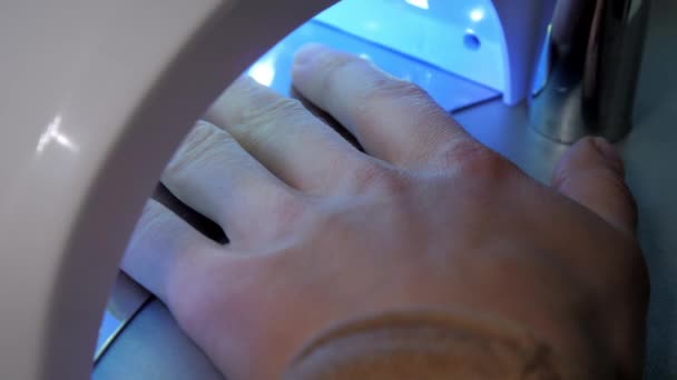 Kosmetický salon návštěvník vysuší základní gel v ultrafialové lampě — Stock video
